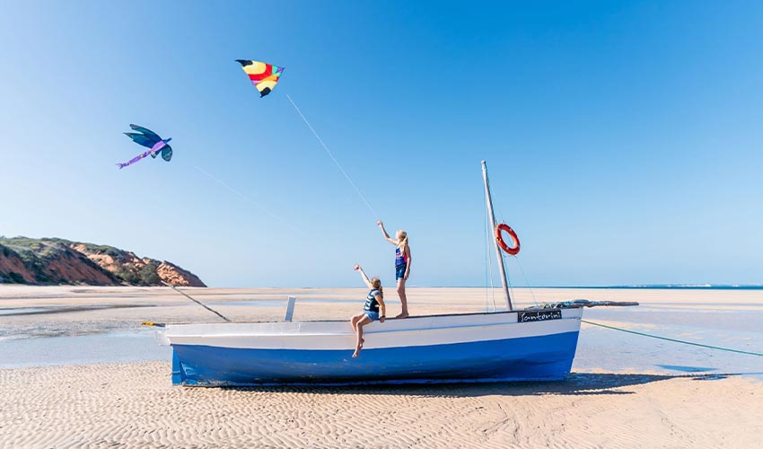 Children playing on a boat on the beach, on a family safari through South Africa and Mozambique